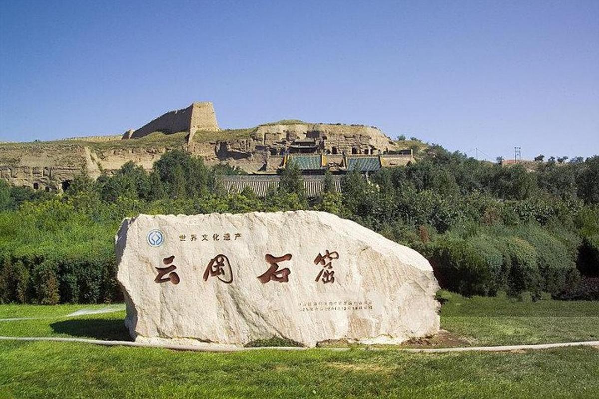 a rock with chinese writing on it in a field