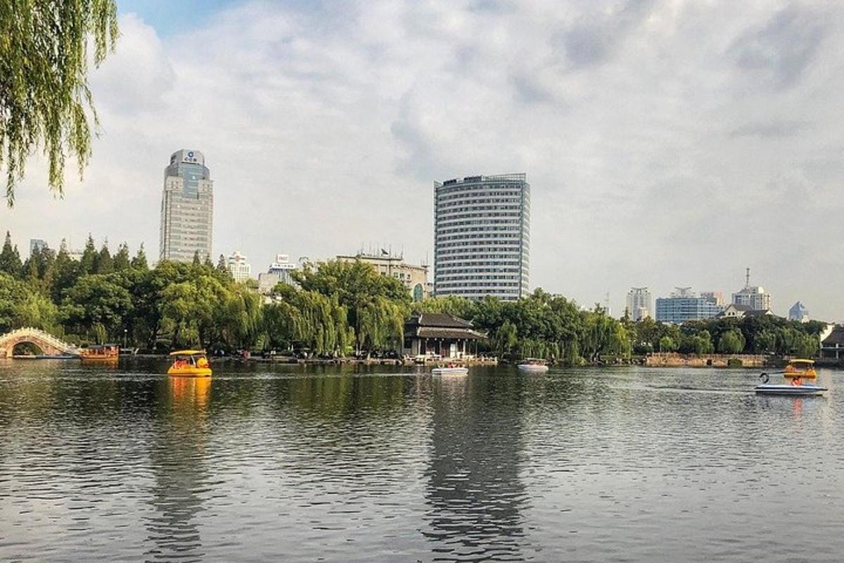 a river with boats in a city with tall buildings