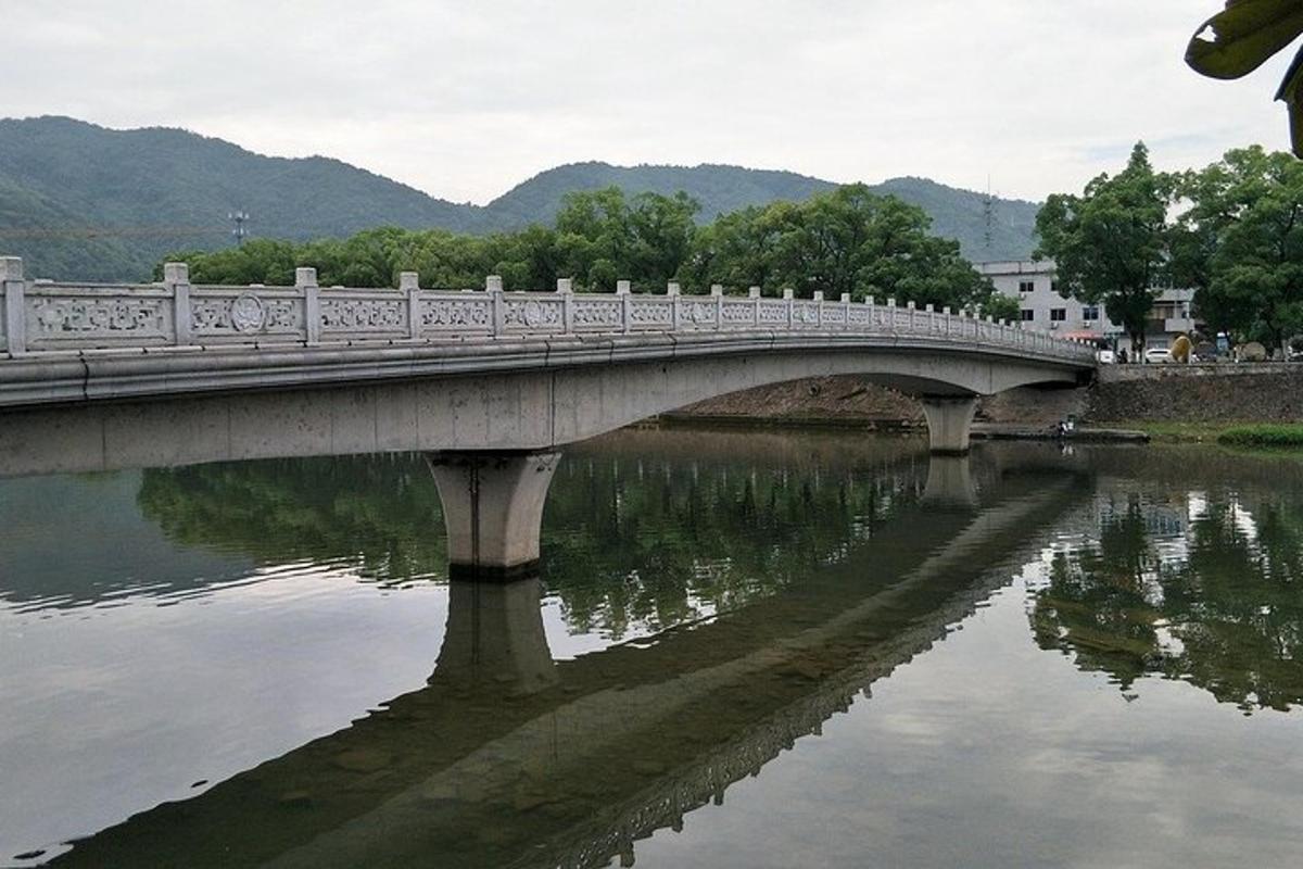 a bridge over a river with reflections in the water