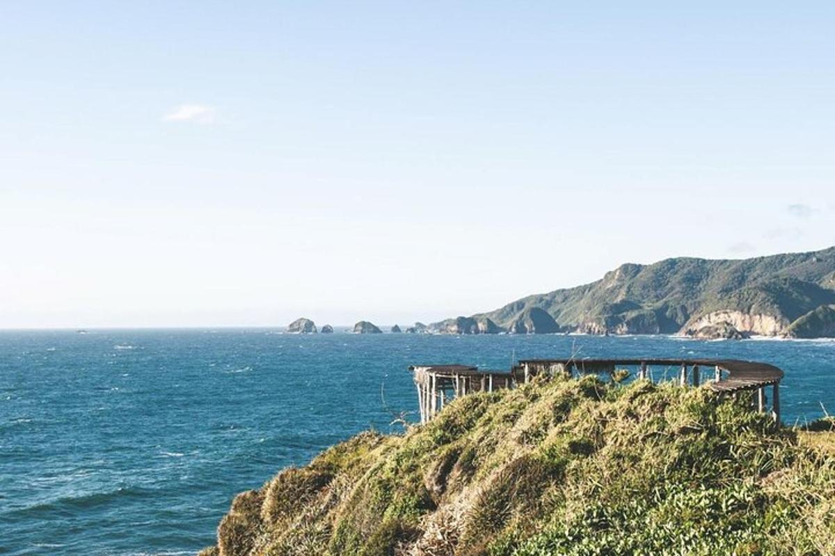 a building on top of a hill next to the ocean