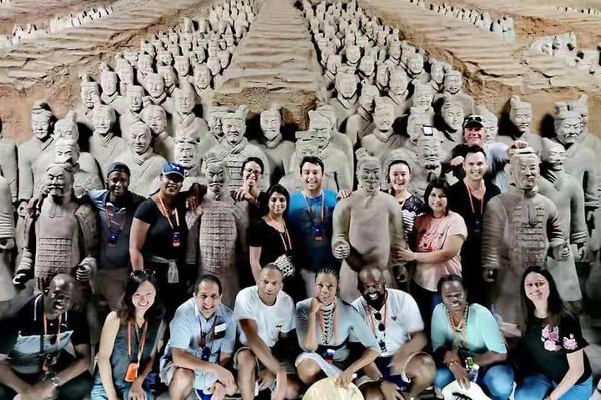 a group of people posing for a picture in front of statues