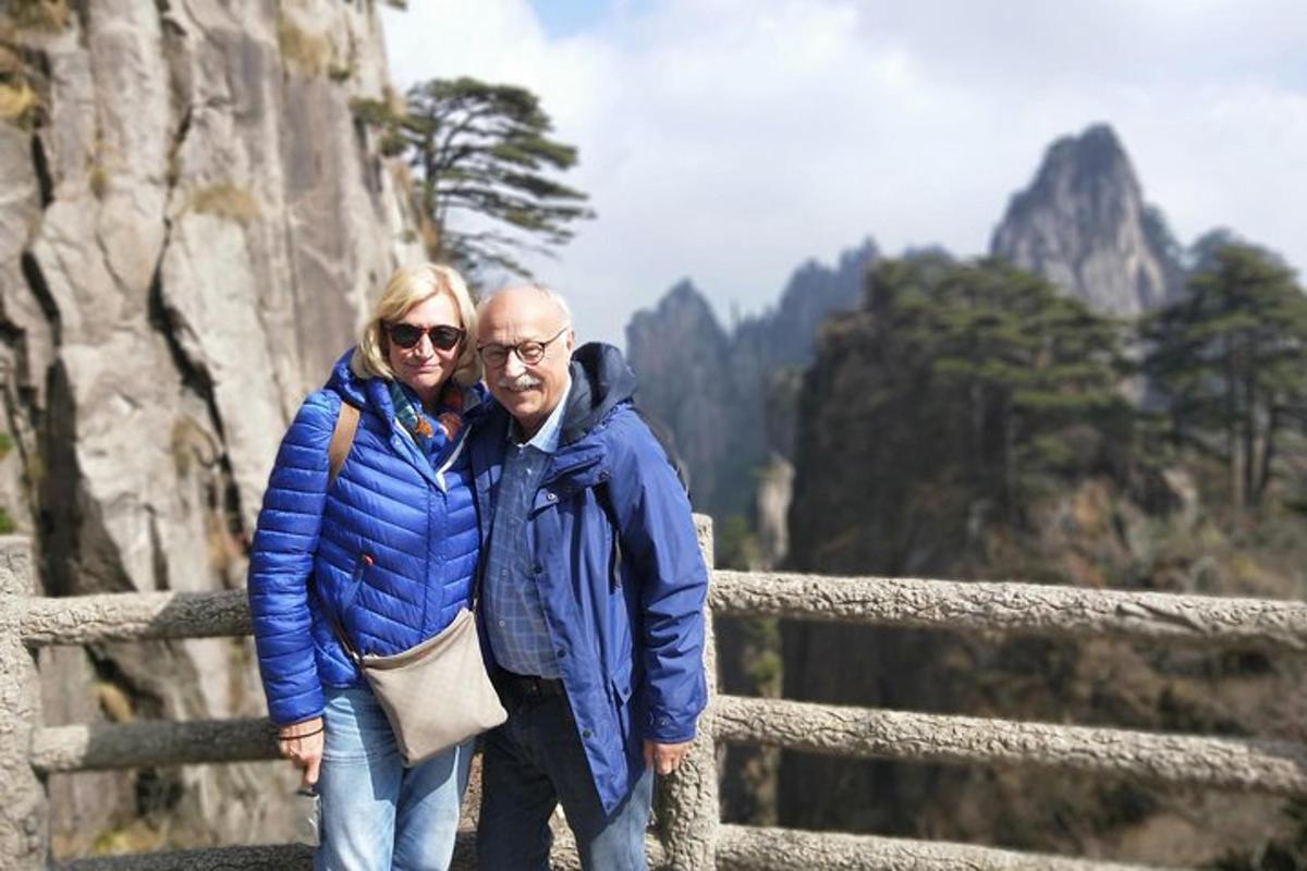 Un hombre y una mujer de pie junto a una montaña