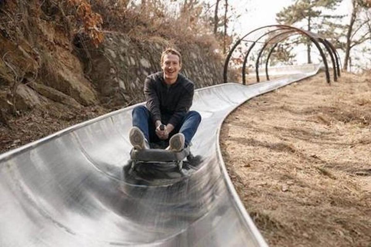 a man sitting on a skateboard on a ramp