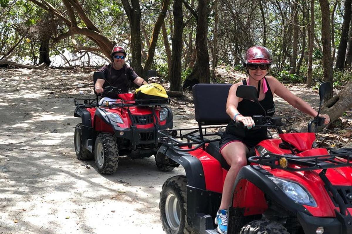 a man and a woman riding atvs on a trail