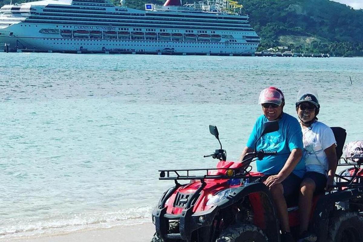 a man and woman sitting on a atv on the beach with a cruise ship