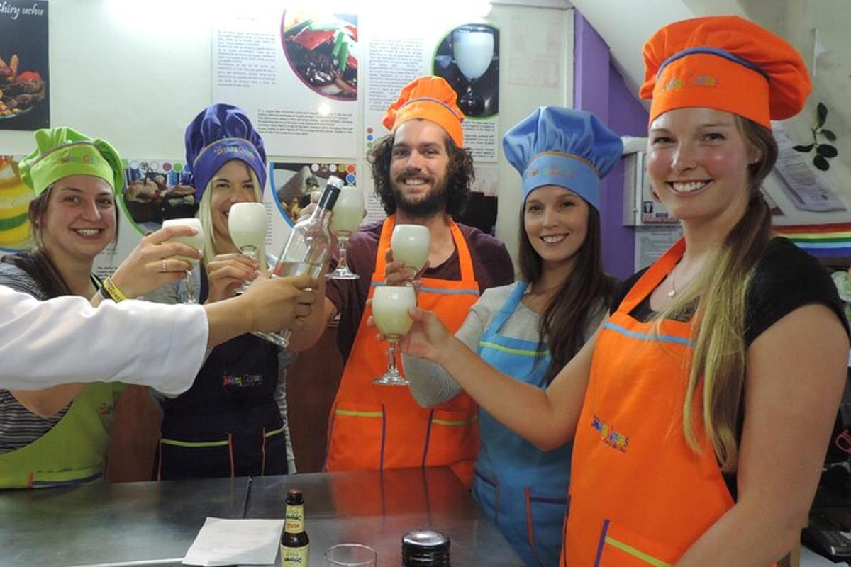 skupina ljudi v predpasnikih, ki držijo kozarce za vino
