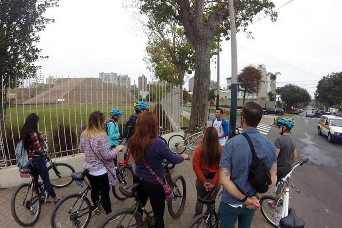 un gruppo di persone in piedi su un marciapiede con le biciclette