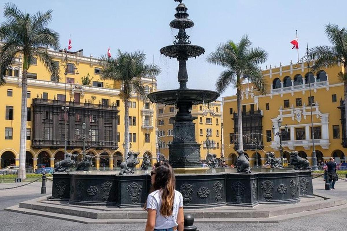 a woman standing next to a fountain in front of a building