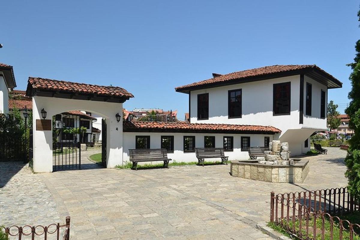 un grande edificio bianco con panchine in un cortile