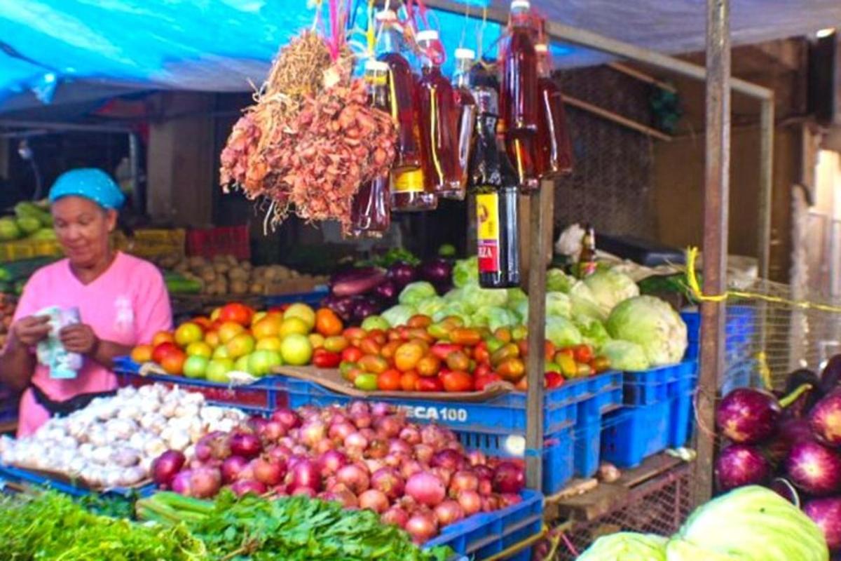 a woman standing in a market with fruits and vegetables