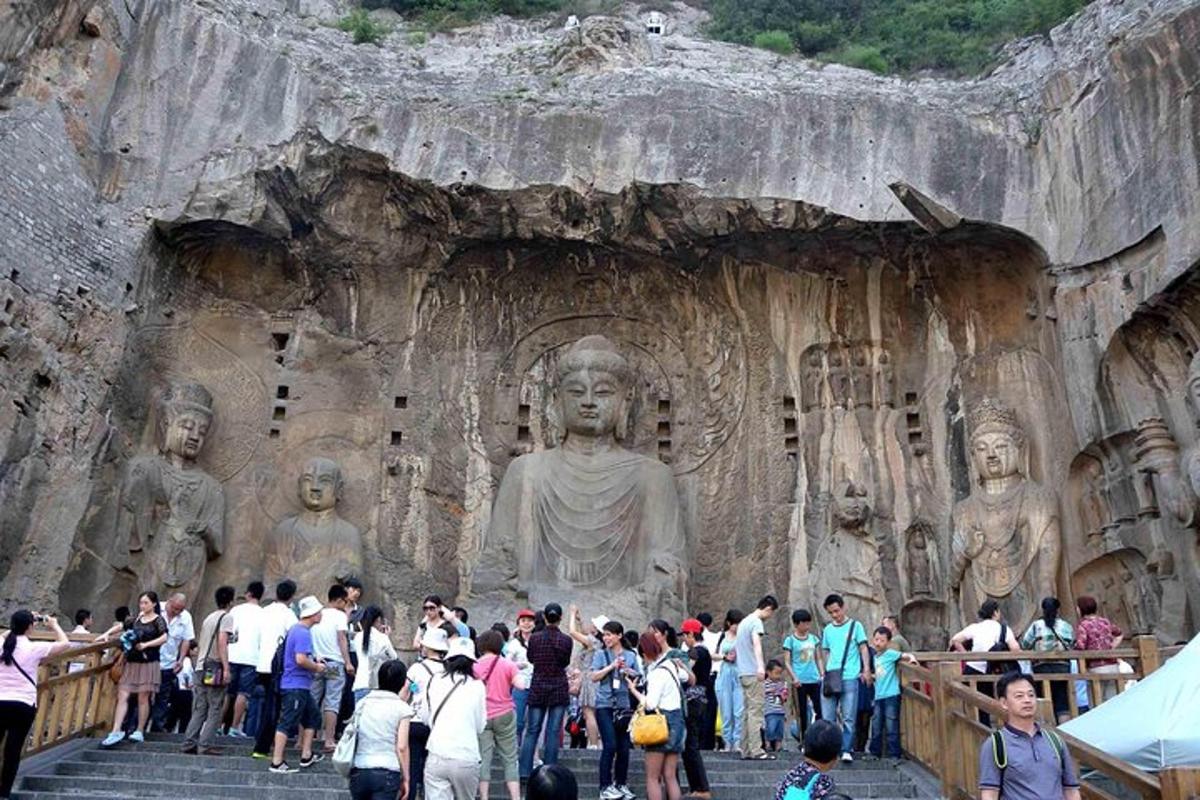 a crowd of people standing in front of a large statue