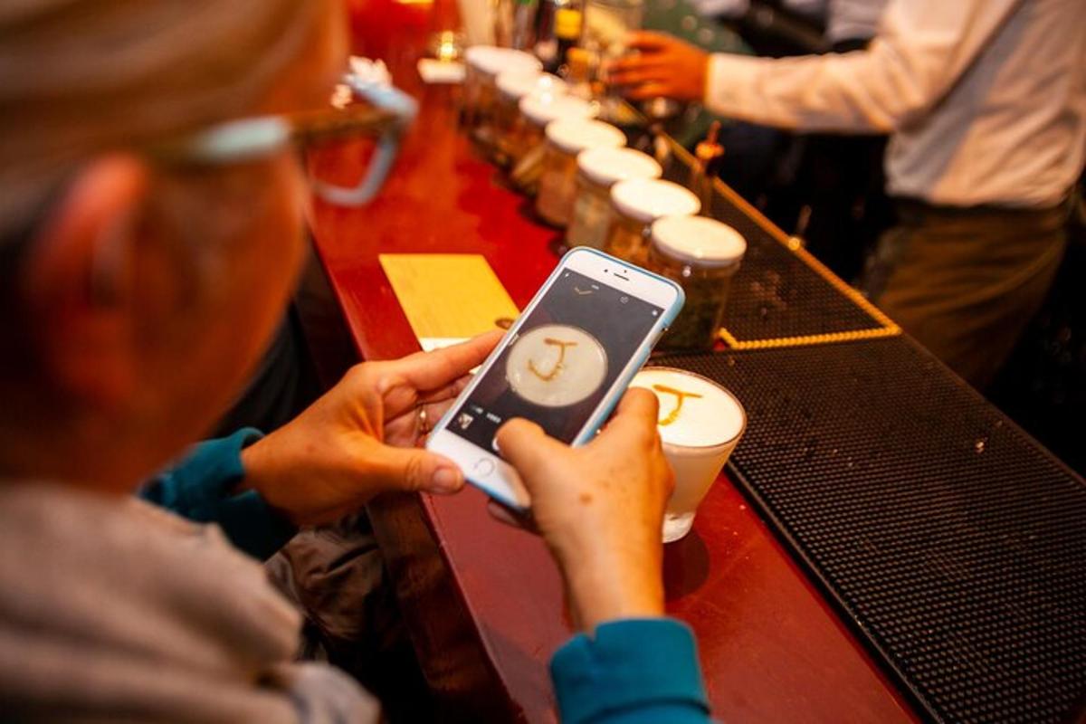 una persona che tiene in mano un cellulare davanti a un bar