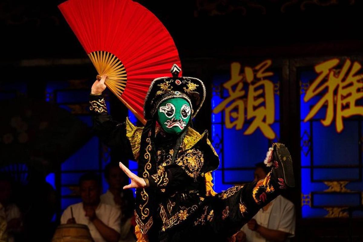 戴着面具的人拿着一把红伞和一把扇子