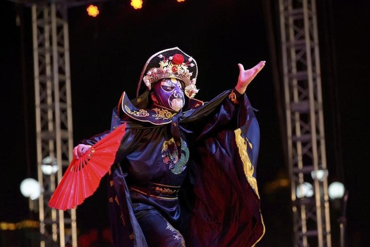 a person dressed in a mask and costume with a red umbrella