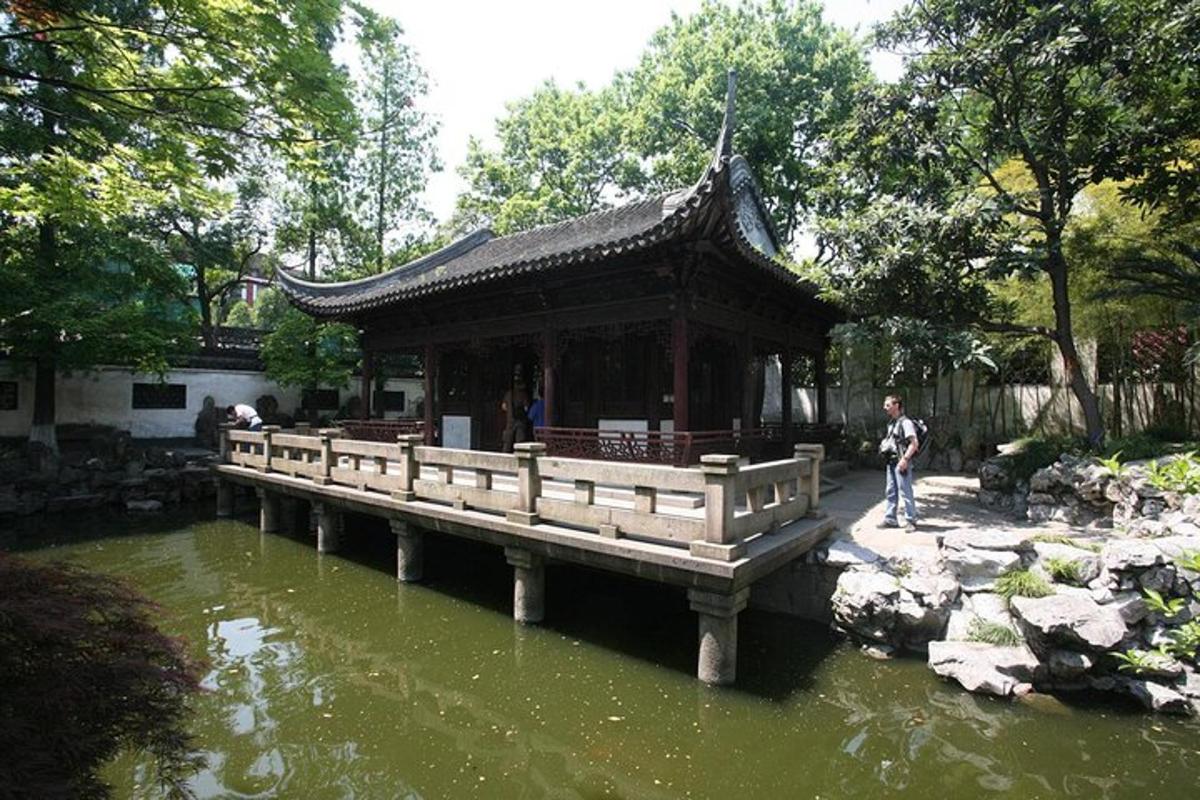 a pavilion over a pond in a garden