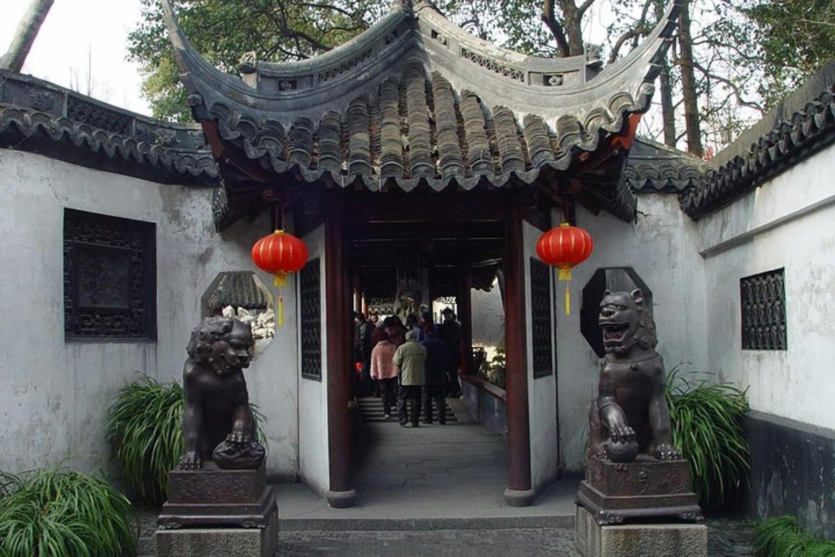 一座有两尊雕像和红灯笼的建筑入口