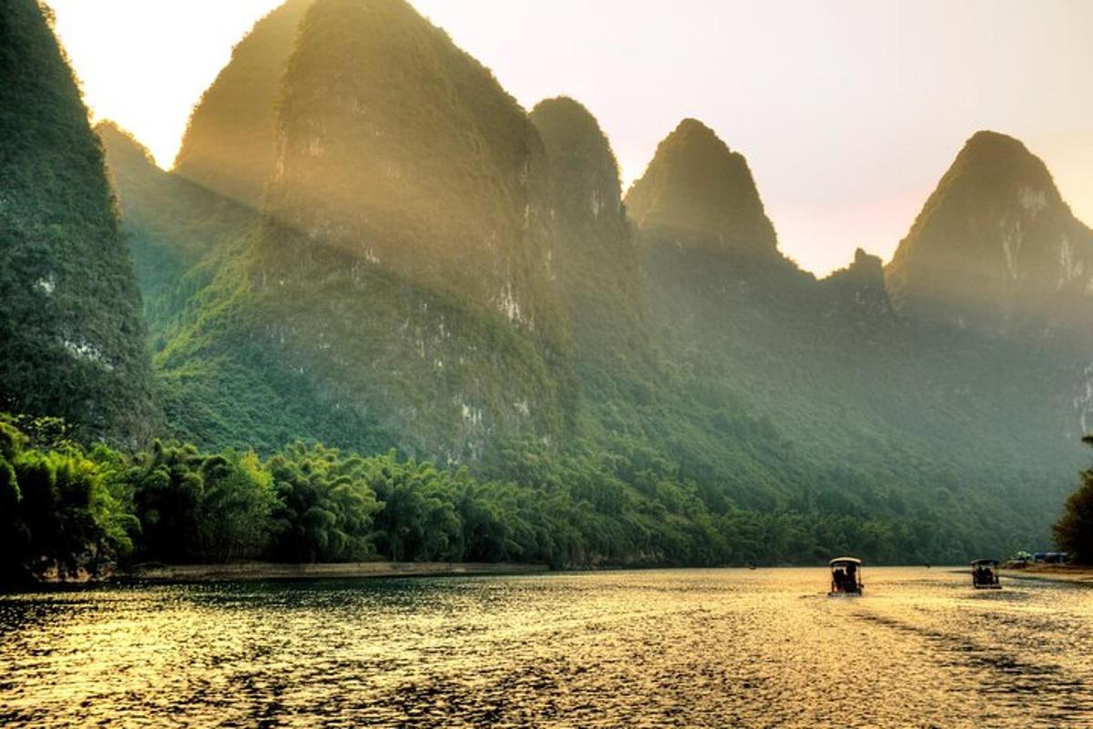 a river in front of mountains with a boat on it