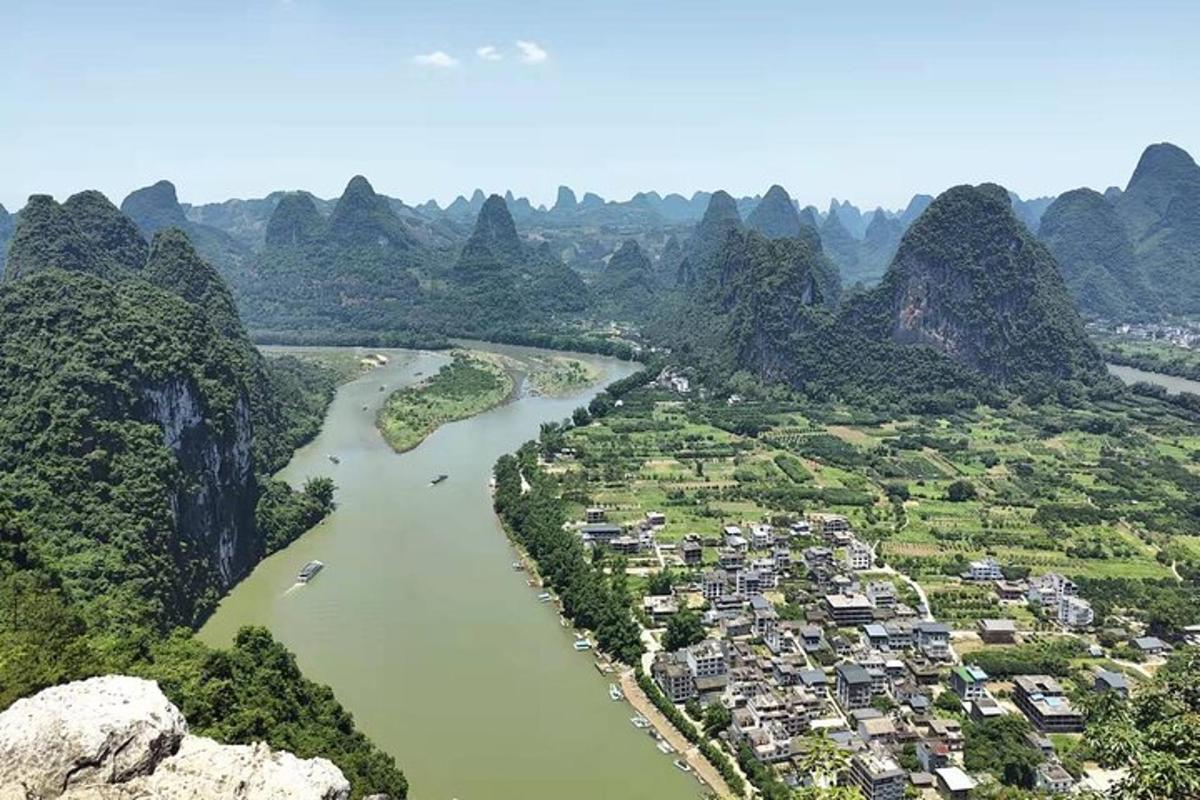an aerial view of a river with mountains and houses