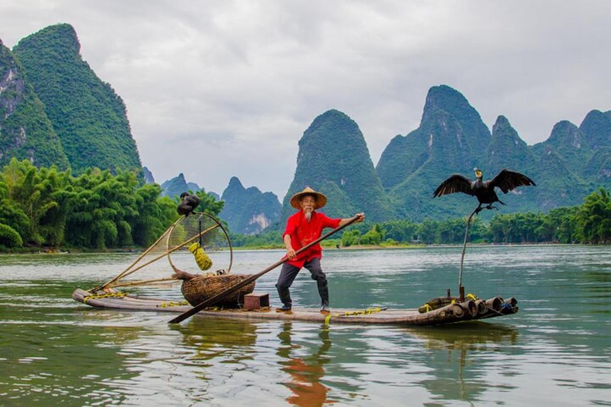 a young boy standing on a boat in the water with a bird