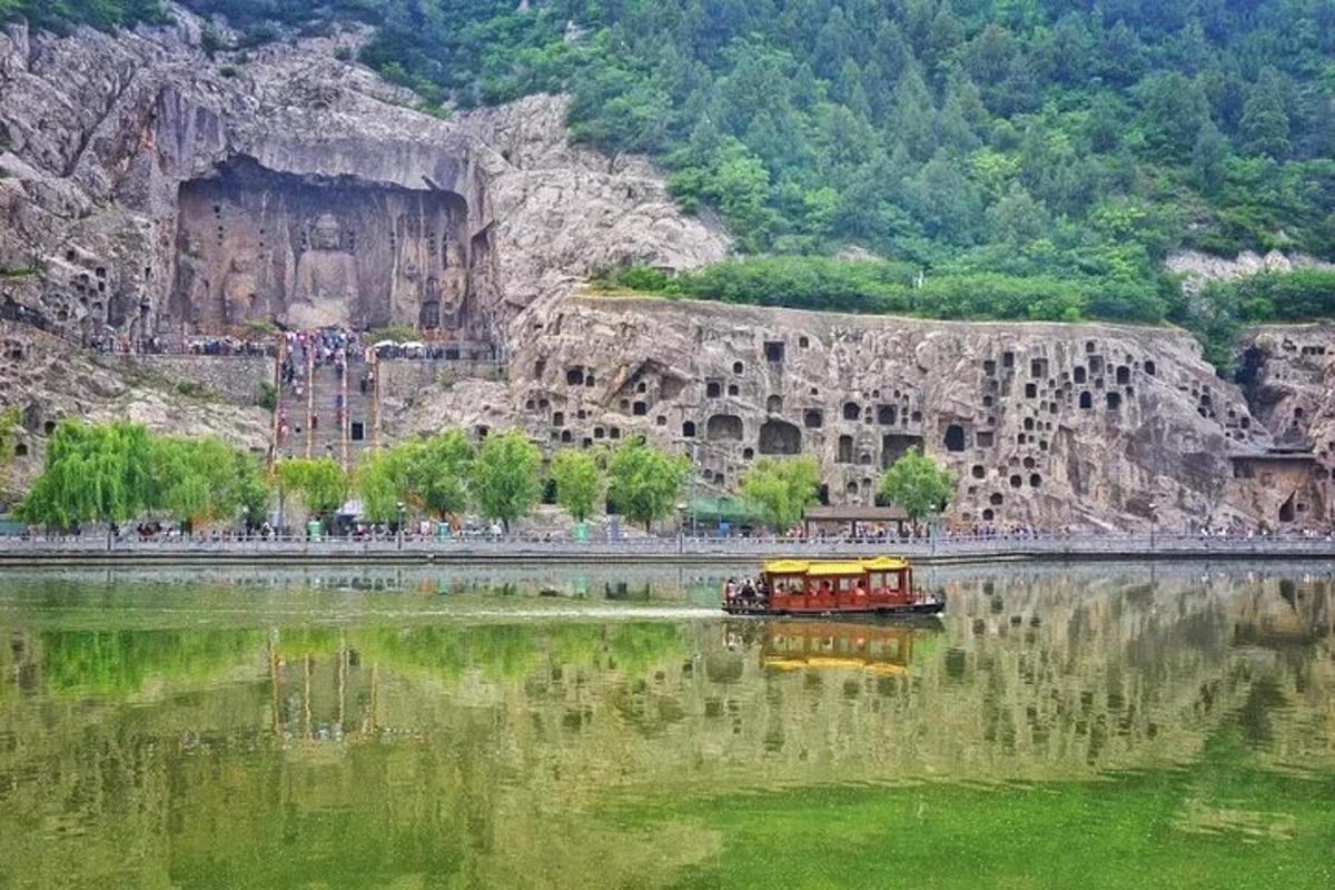 a boat in the water next to a mountain