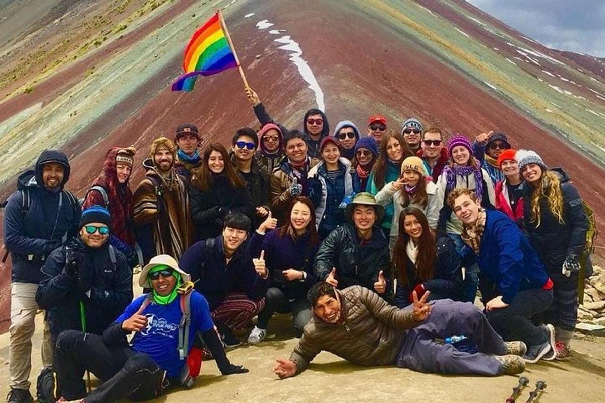 un gruppo di persone in posa per una foto con una bandiera arcobaleno