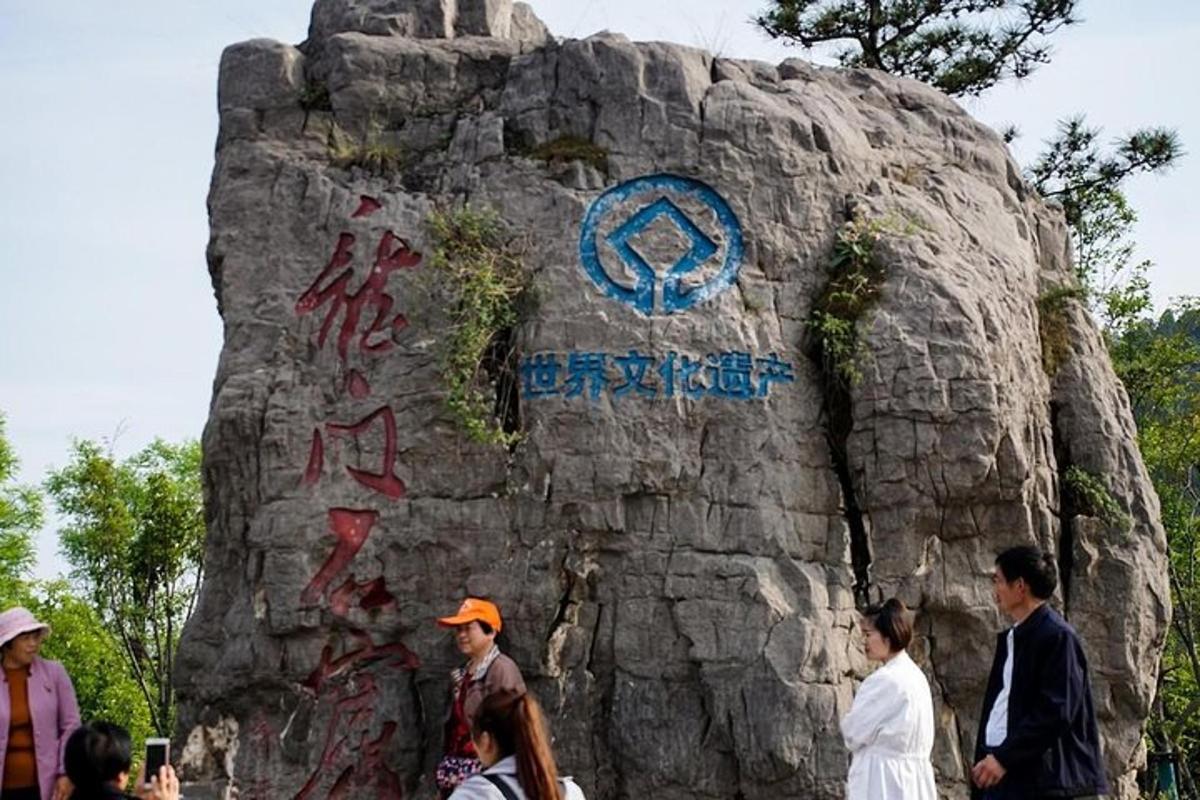 a group of people standing in front of a rock wall