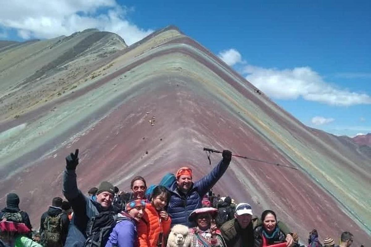 un gruppo di persone in piedi di fronte a una montagna