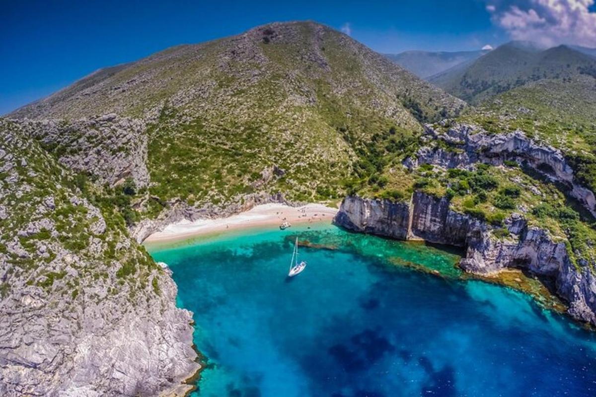 otok s plažom i brodom u vodi