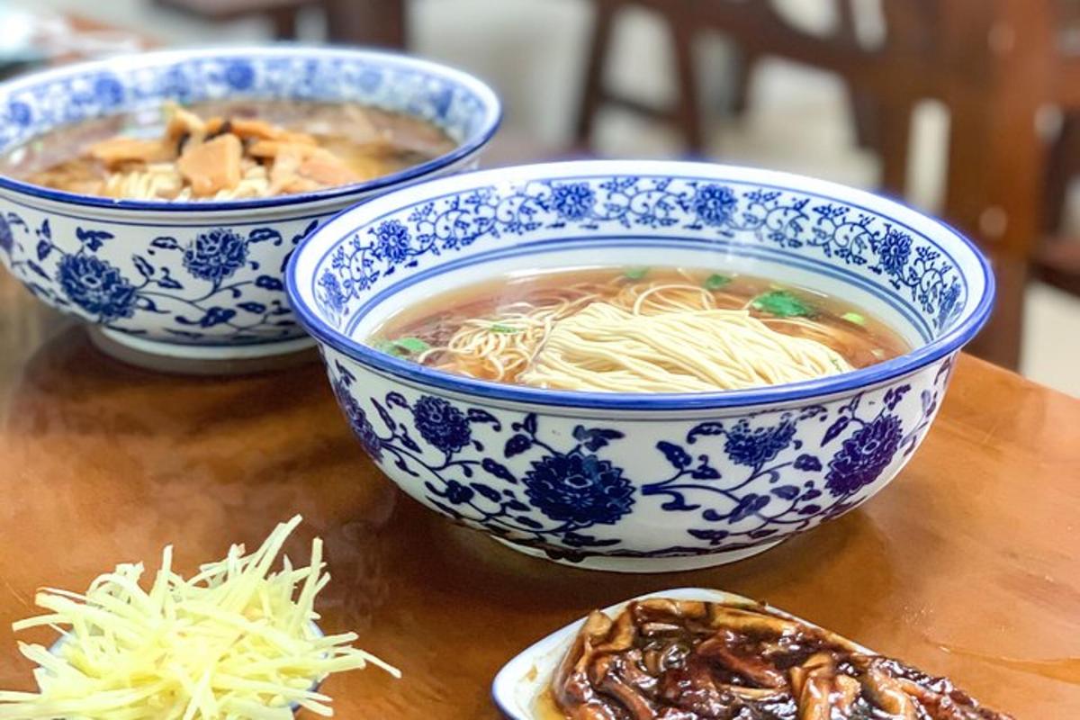 three blue and white bowls of soup on a table