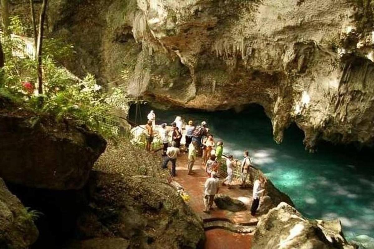 a group of people standing in front of a cave