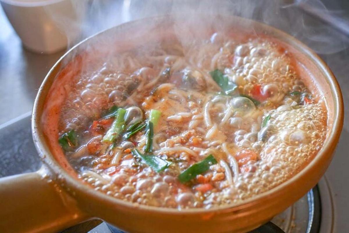 a bowl of soup with noddles and beans