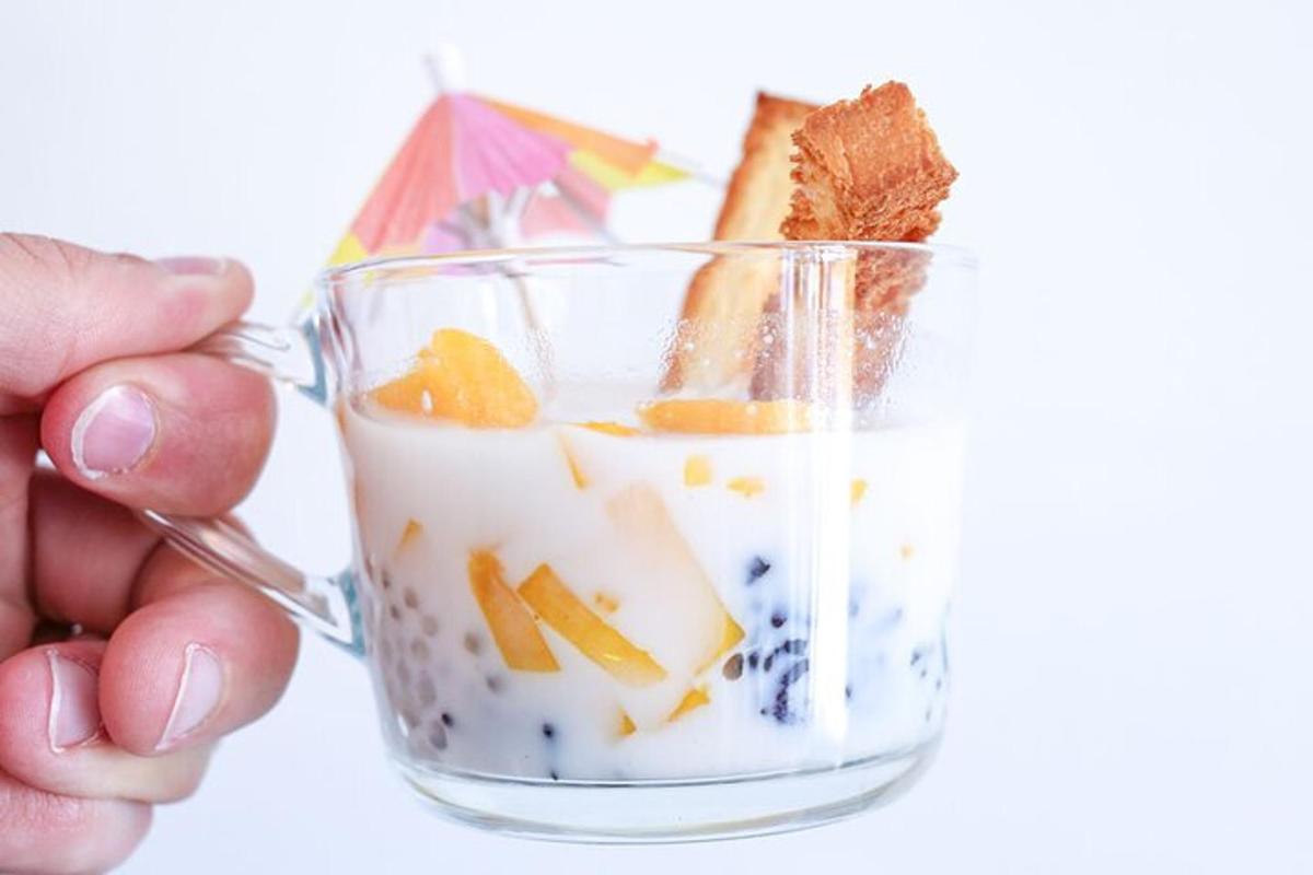 a hand holding a glass jar filled with food