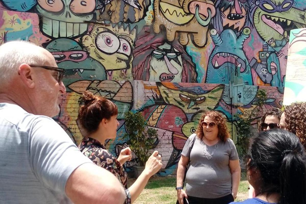 skupina lidí stojících před zdí s graffiti