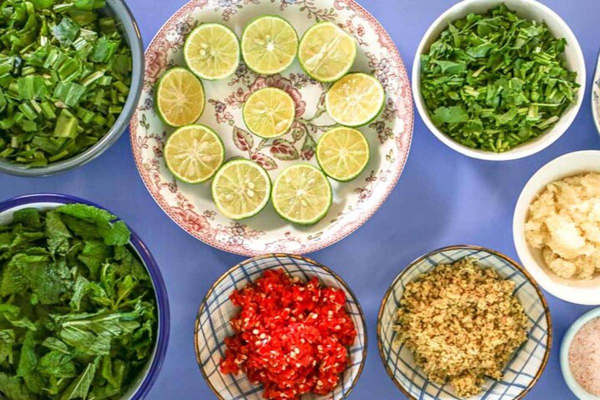 a blue table topped with bowls of food with vegetables