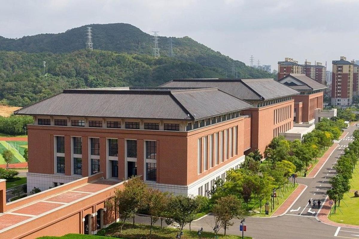 a large brick building with a mountain in the background