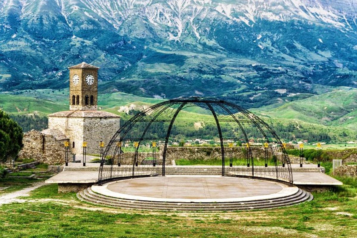 um edifício com uma torre de relógio em frente a uma montanha
