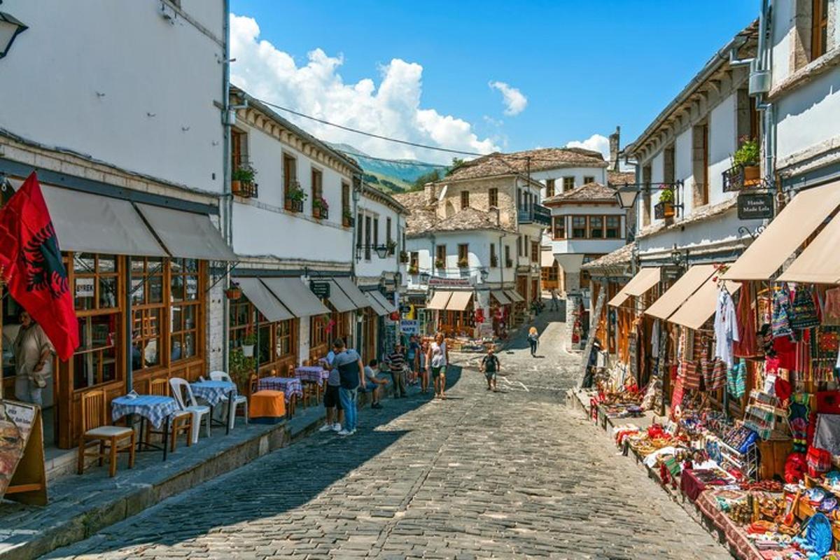 una strada acciottolata in una città con persone che la percorrono