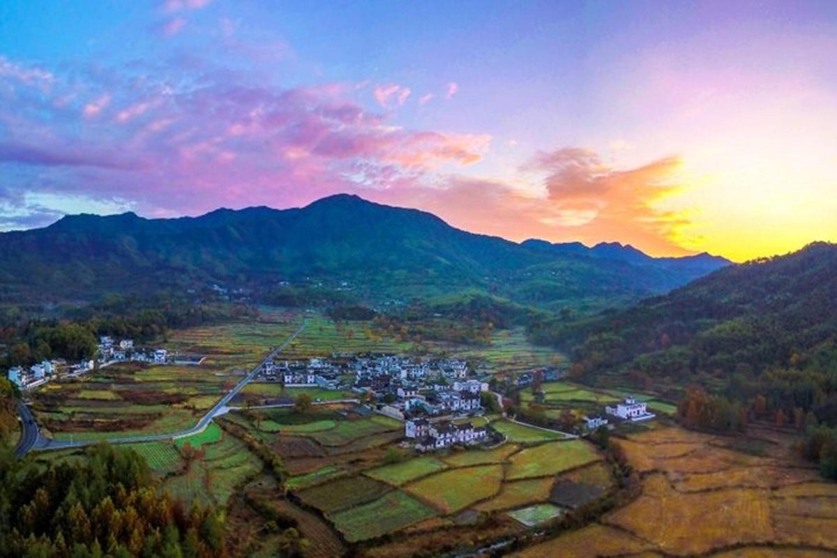 an aerial view of a town in a valley with mountains
