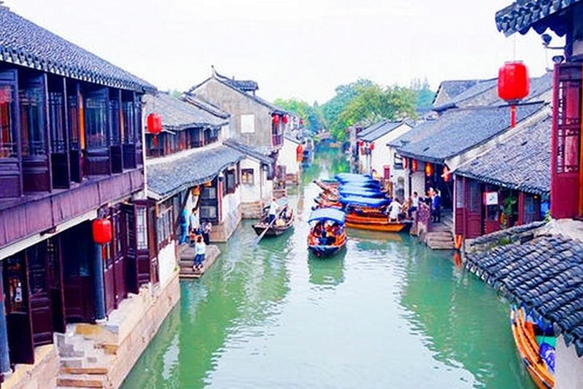 a group of boats in a river between buildings