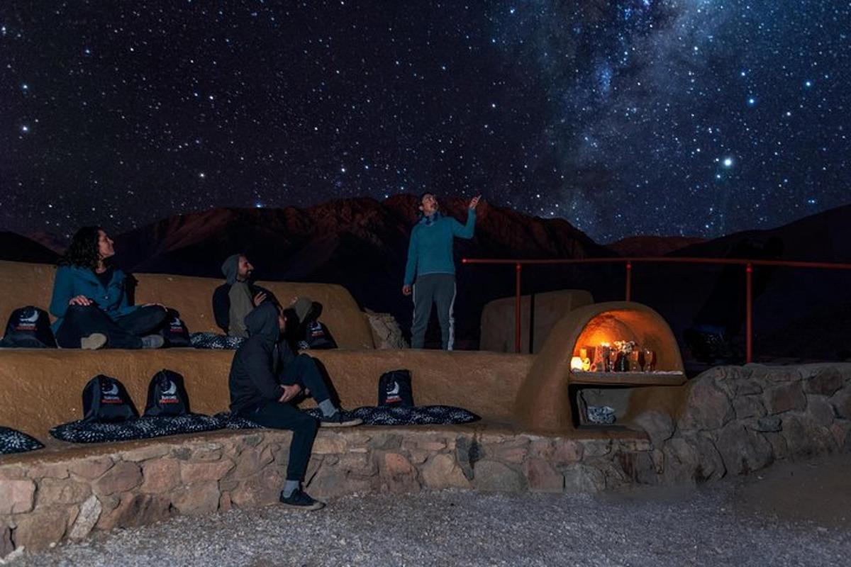 a group of people sitting on a wall under a starry sky