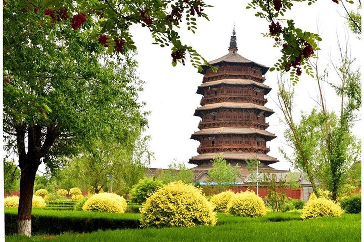 a large pagoda in a park with a tree