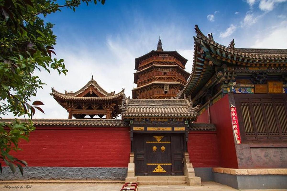 a building with a red wall and a large tower