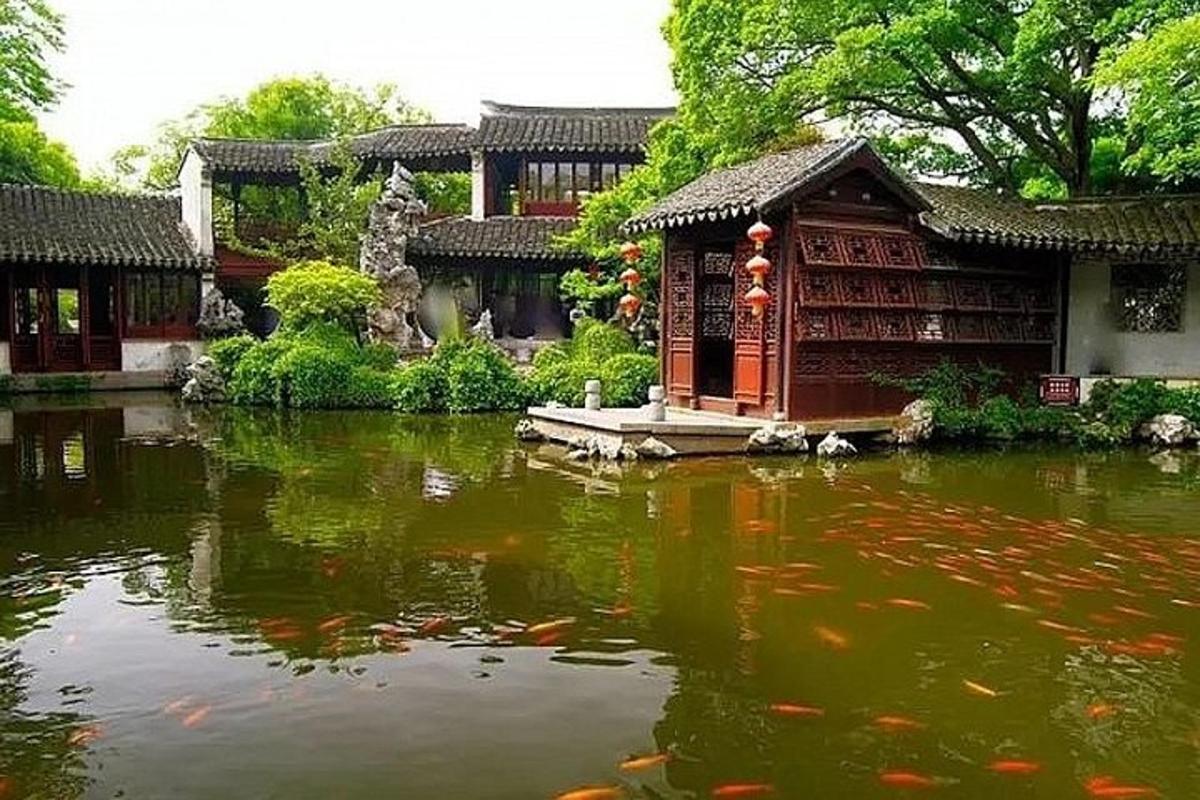 a pond in front of a building with koi