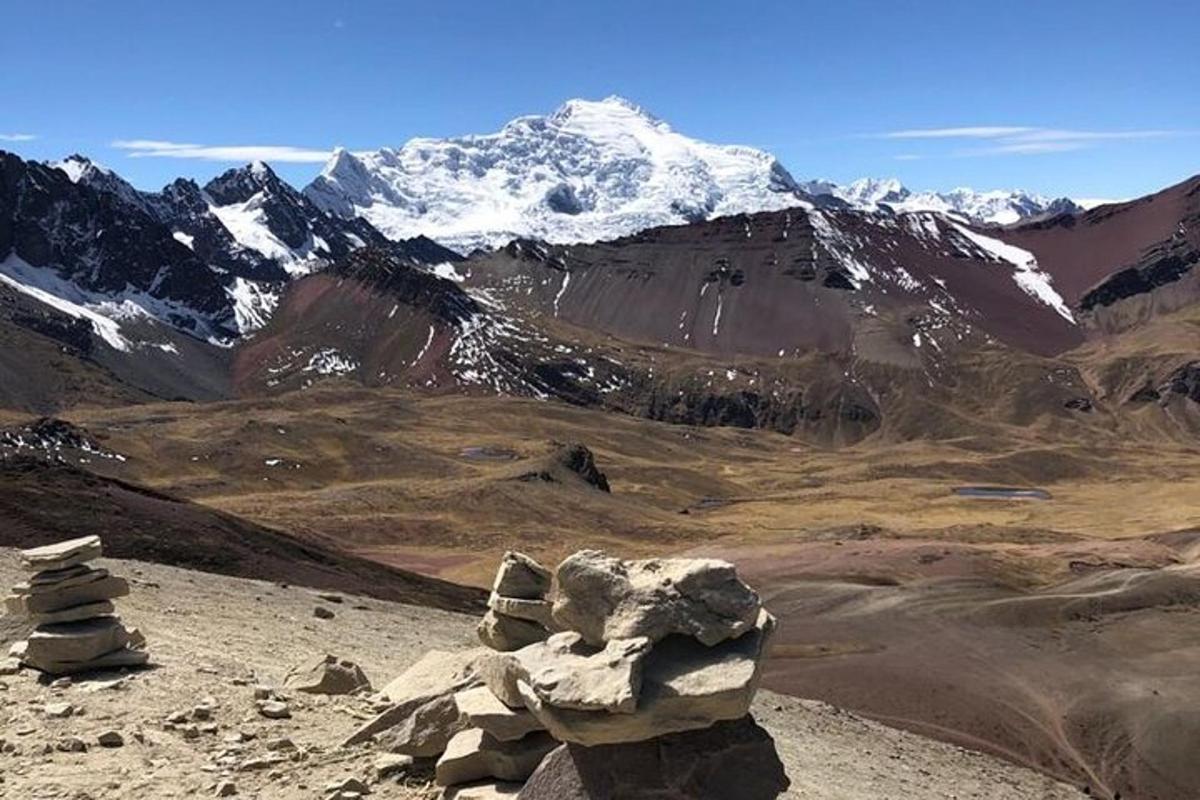 snæviþakið fjall með klettamyndun í forgrunni