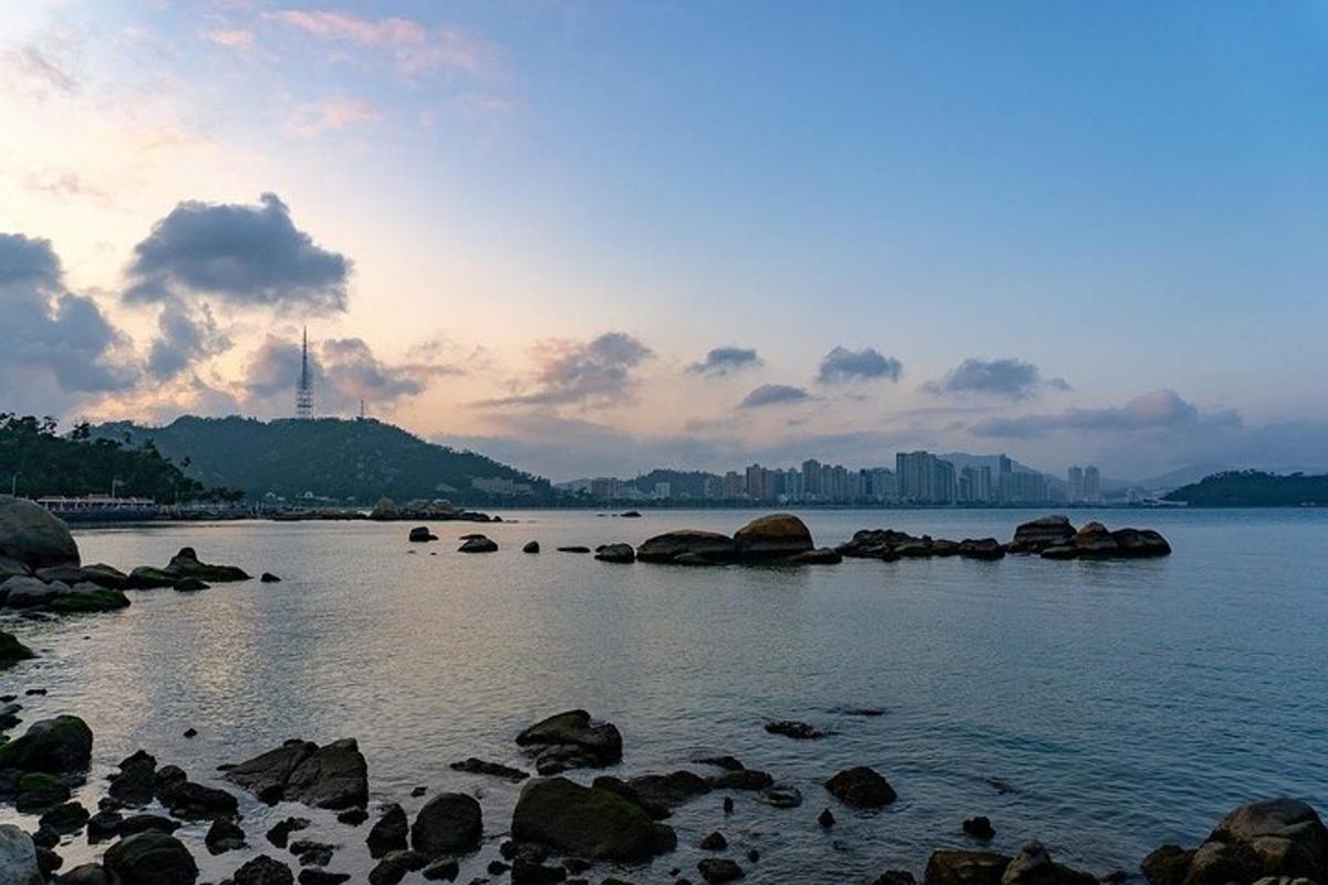 un grande specchio d'acqua con rocce e una città
