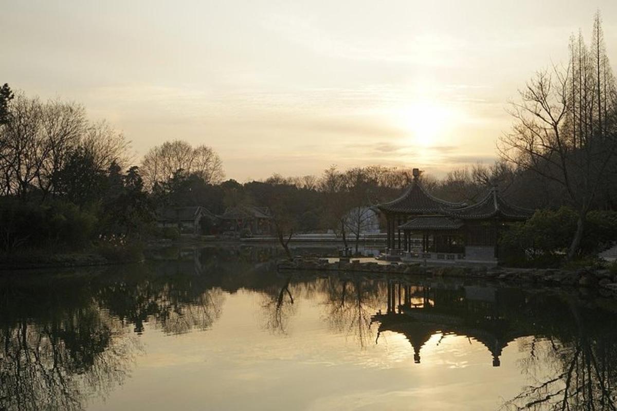 a sunset over a lake with a pagoda in the distance