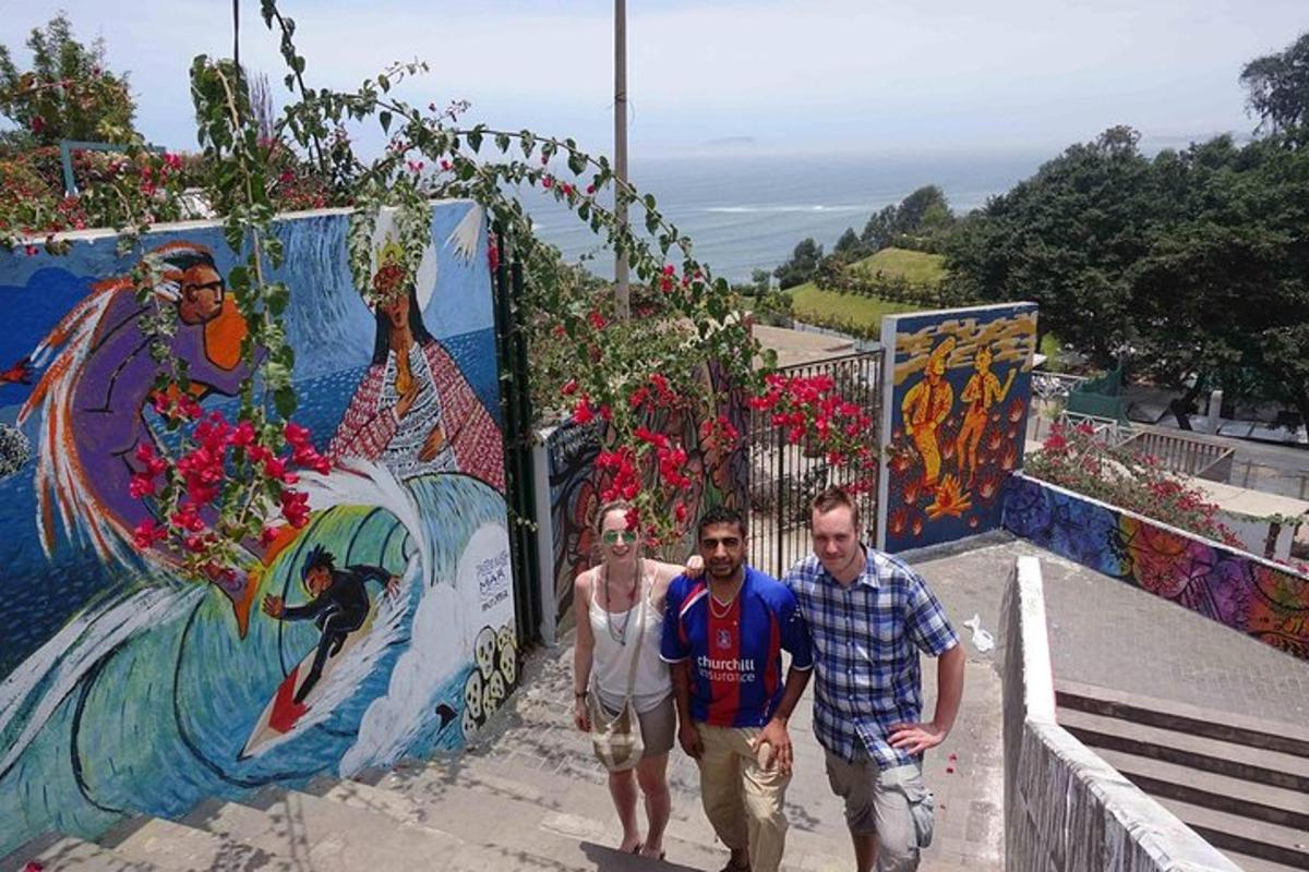 trei bărbați stau lângă un zid cu graffiti