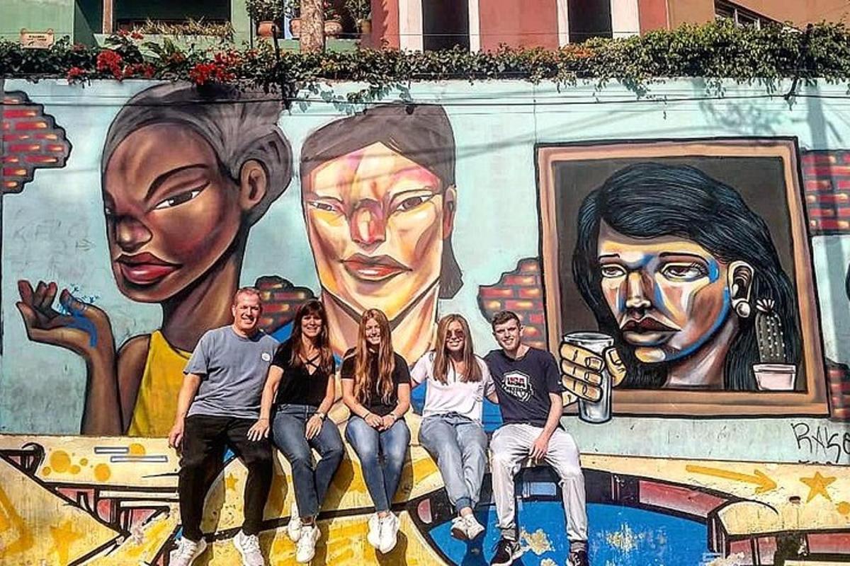 un grup de oameni așezați în fața unei picturi murale