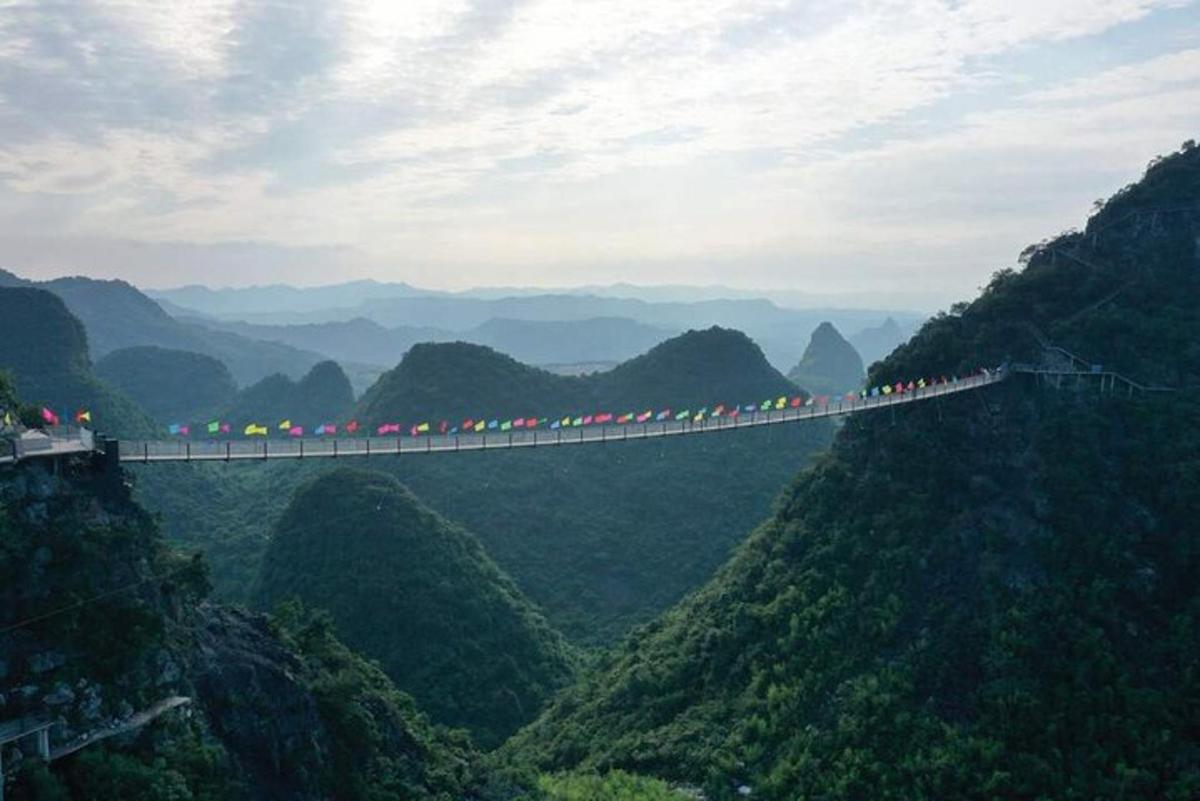 un gruppo di persone su un lungo ponte sopra le montagne