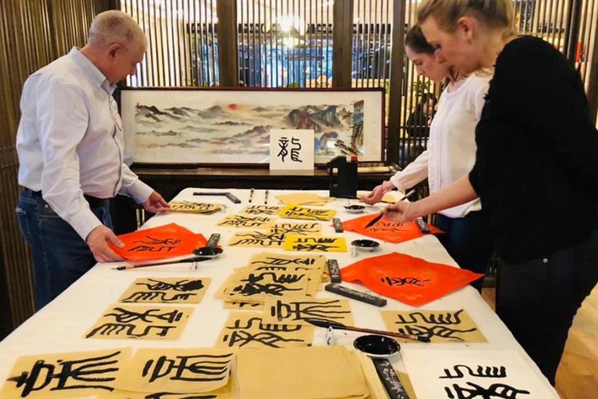 a group of people standing around a table with writing on it